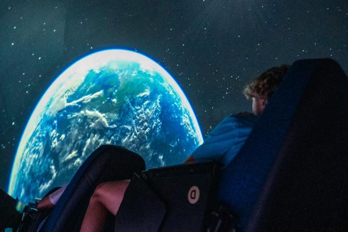 Students looking at the planet Earth being displayed in the planetarium